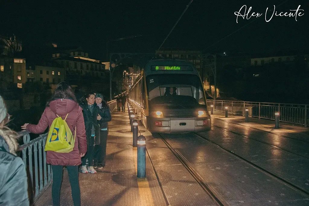 A tram moving through Porto at night.