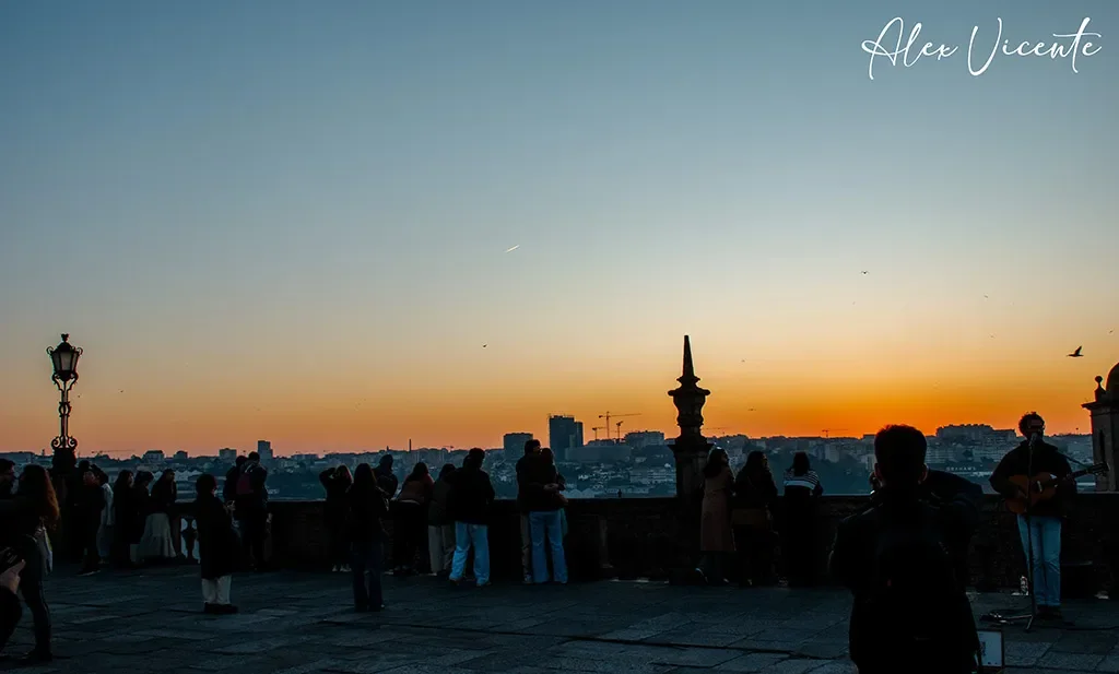 A musician performing above Porto at sunset.
