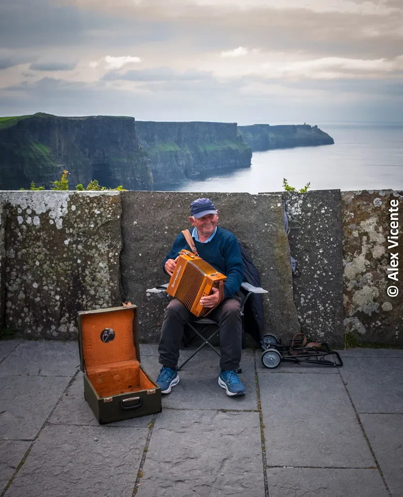 A musician playing accordion at the Cliffs of Moher.