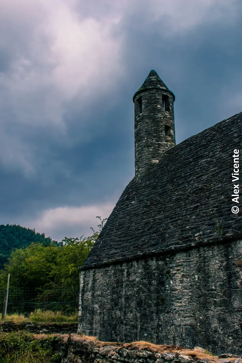 An old Irish church beneath dense clouds.